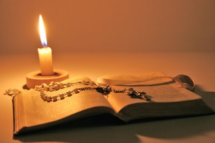 Bibelstudium bei Kerzenlicht Bibel und Rosenkranz